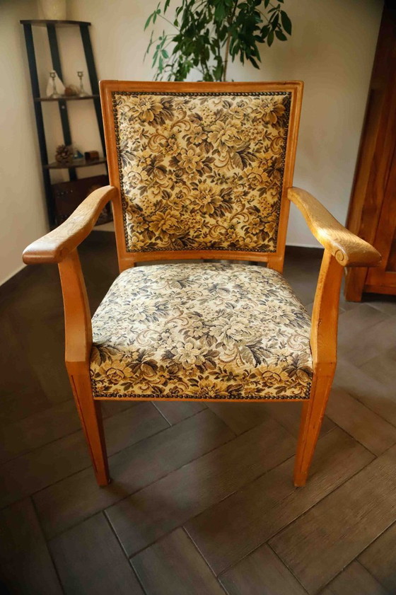 Image 1 of Vintage salonfauteuil met bloemenpatroon op de bekleding en sierlijke armleuningen.