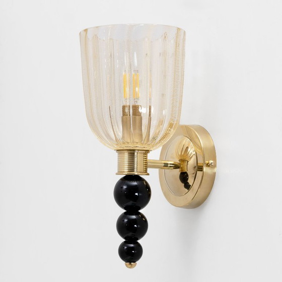 Image 1 of Een paar Italiaanse wandlampen van Murano-glas met goudstofaccenten en messing.