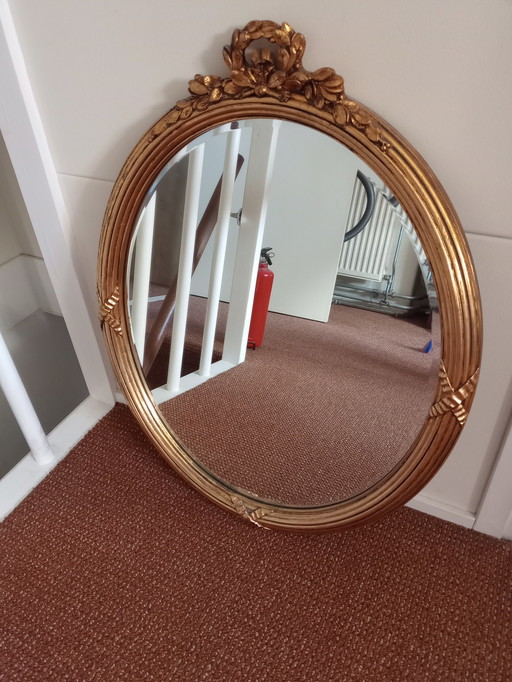 Espejo ovalado de color dorado