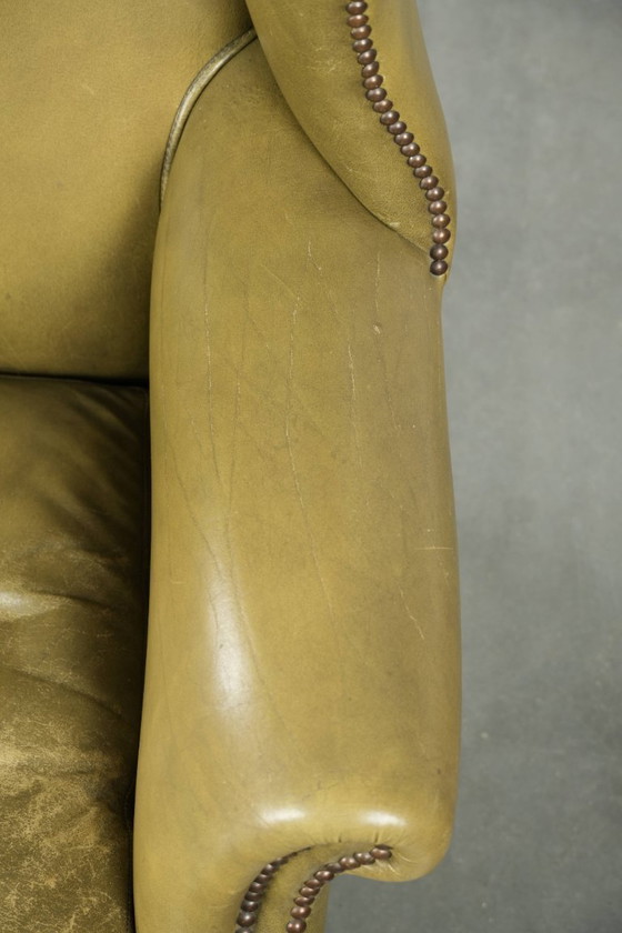 Image 1 of Fauteuil à oreilles ancien et élégant en cuir de vachette vert, de style classique de maison de campagne anglaise.