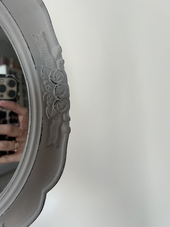 Image 1 of Specchio ovale in legno bianco con intagli floreali.