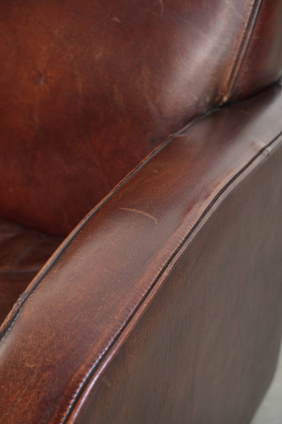 Image 1 of 2x dunkel cognacfarbene Schaffellsessel mit abgerundeten Formen und elegantem Design
