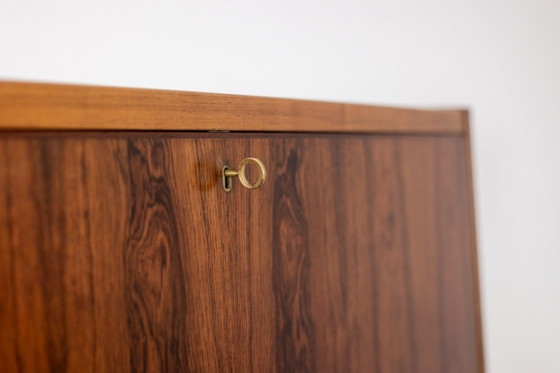 Image 1 of Commode van palissanderhout met 2 laden, die tevens als secretair dient. Jaren 70.