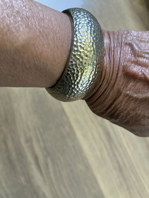 Bracciale in metallo martellato con chiusura a scatto.