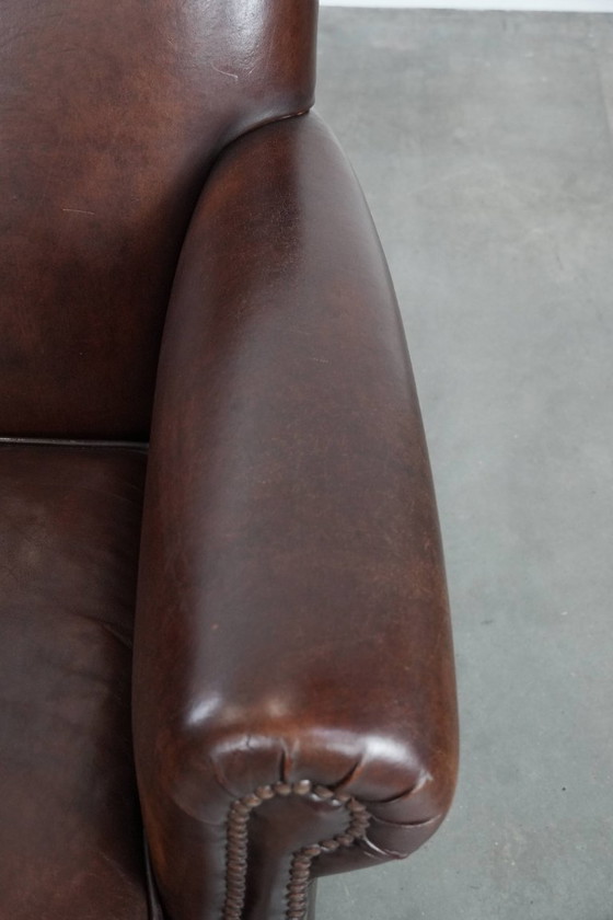 Image 1 of Fauteuil en peau de mouton aux couleurs chaudes et à la finition classique orné de clous décoratifs