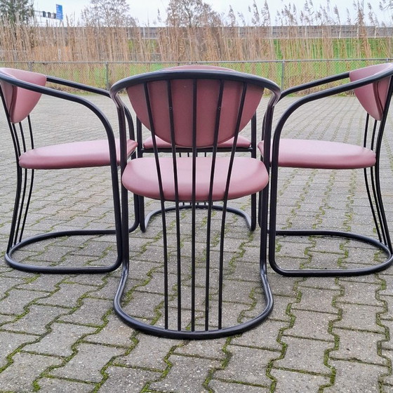 Image 1 of This is a set of four vintage 'Memphis' style chairs with a black metal frame and burgundy upholstery.