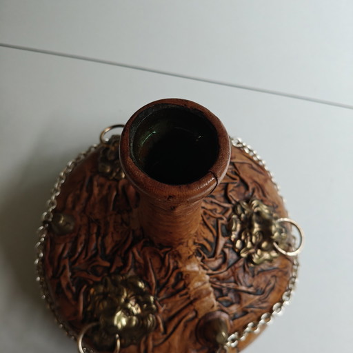 Carafe vintage recouverte de cuir, ornée de têtes de lion et d'une chaînette