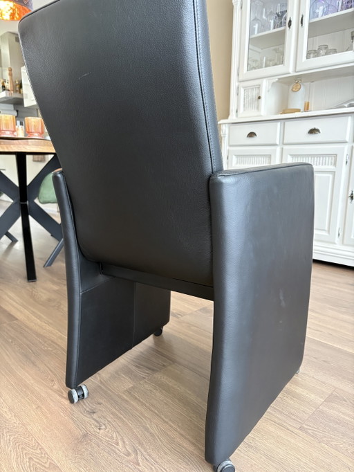 4 sillas de diseño de cuero negro de la marca Sijben con ruedas.