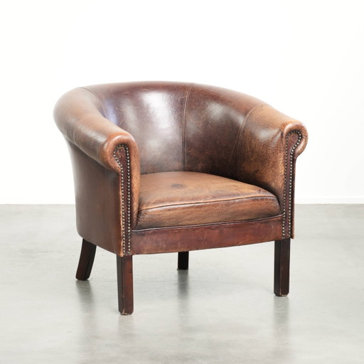 Beau fauteuil club en cuir de mouton avec une belle patine, de taille subtile et un look vintage
