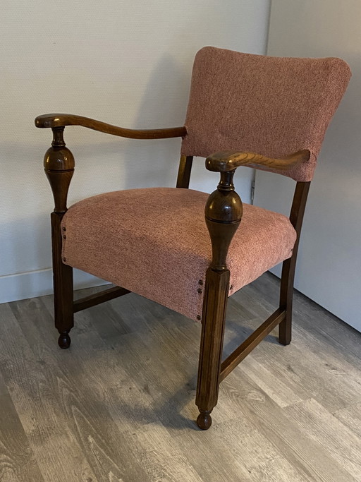 Magnifique fauteuil vintage avec une structure en bois robuste et des accoudoirs élégants.