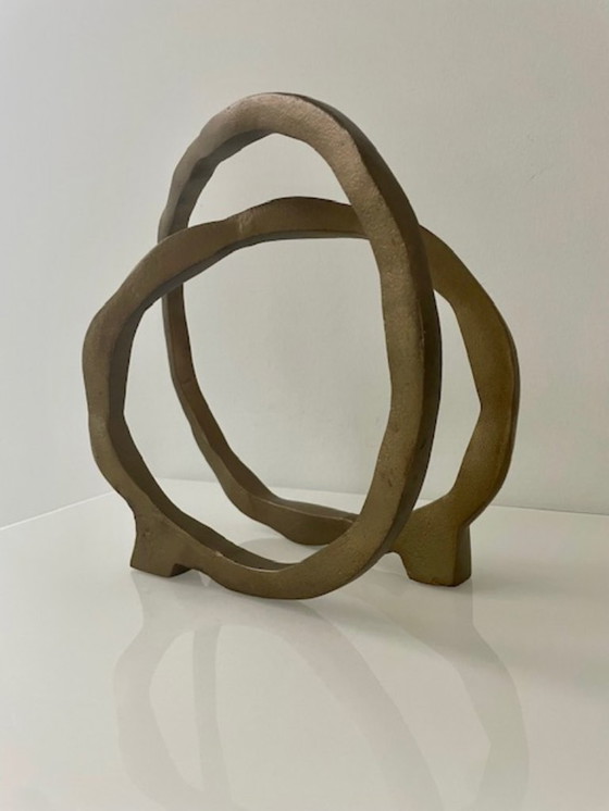 Image 1 of Escultura de diseño con forma de anillo abierto en oro mate.