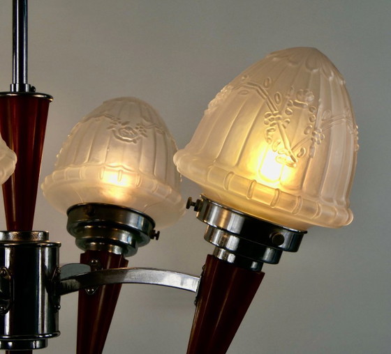 Image 1 of Chrome Art Deco chandelier with four amber Bakelite torches with decorated glass lampshades, ca. 1935