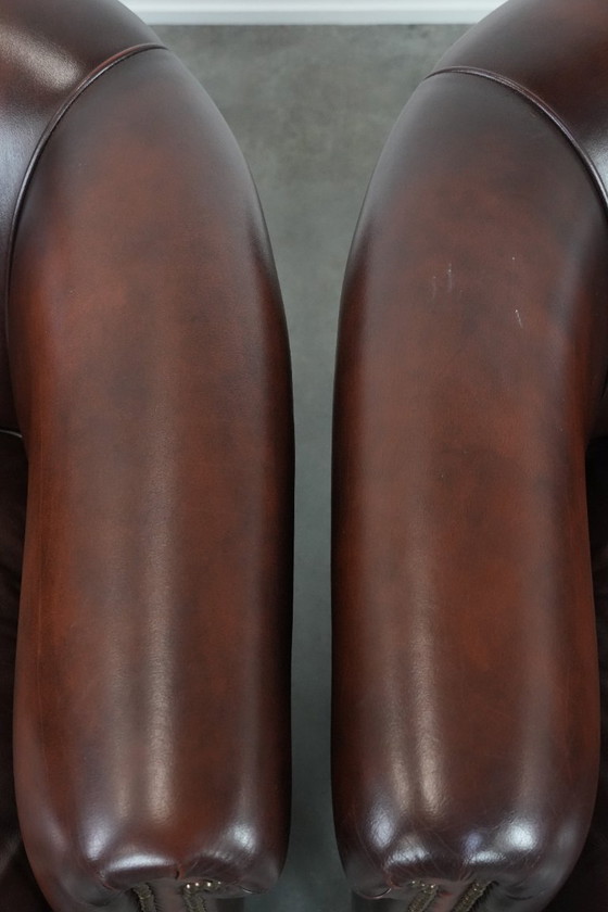 Image 1 of 2 poltrone club in pelle bovina in buone condizioni, di un lussuoso colore rosso/marrone.