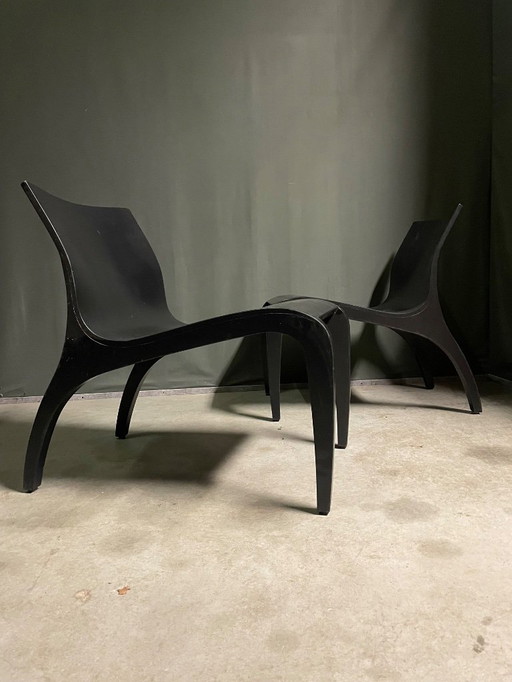 Un par de sillones minimalistas de madera contrachapada curvada.