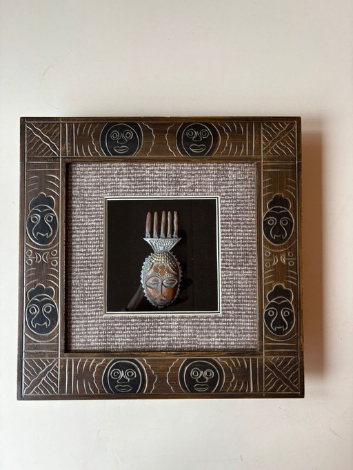 Marco de madera tallado a mano con máscara africana.