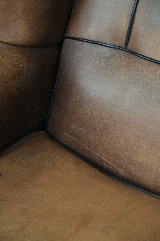 Image 1 of Poltrona a orecchioni in pelle di pecora con profili neri, in buone condizioni.