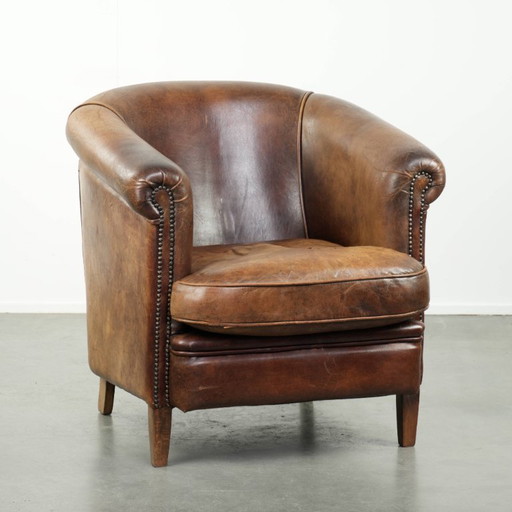 Sturdy and desirable vintage sheepskin club armchair with a beautiful patina and warm colors