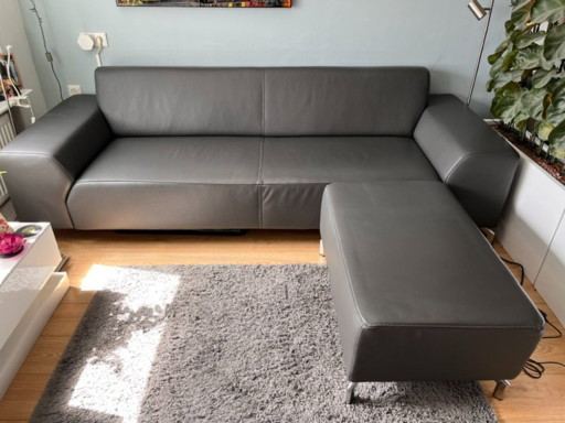 Bellissimo divano di design a 3 posti in pelle grigio/antracite + pouf abbinato.