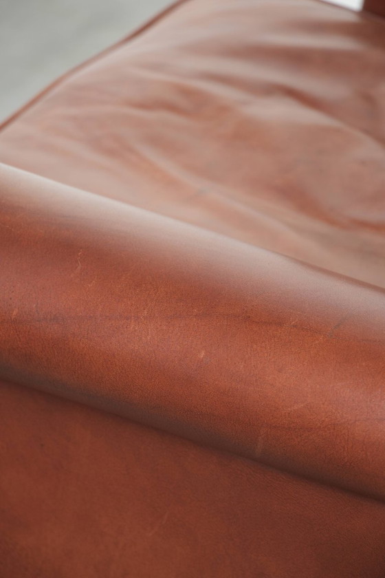 Image 1 of Comoda poltrona a orecchioni in pelle bovina color cognac in stile inglese.