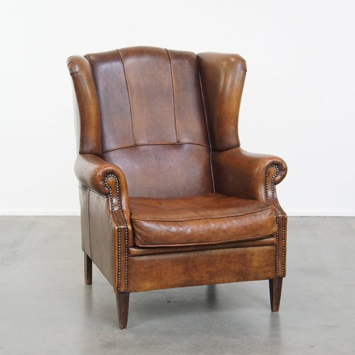 Grand fauteuil à oreilles en cuir de mouton en bon état