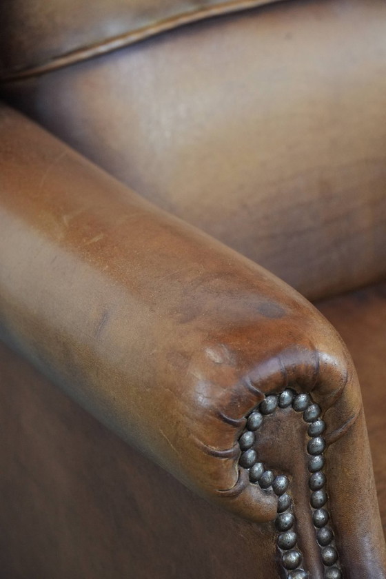 Image 1 of Sillón orejero de piel de oveja acabado con clavos decorativos