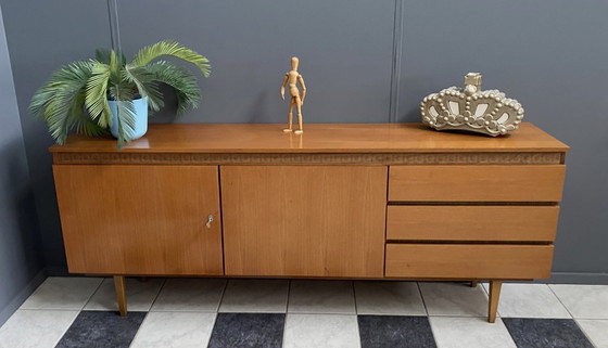 Image 1 of Dressoir uit de jaren 70 met decoratieve lijn boven de deuren.