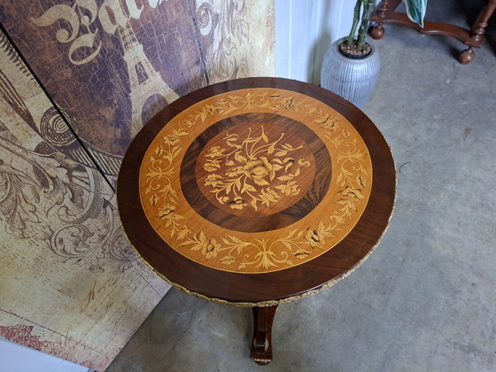 Image 1 of Mesa central redonda clásica de chapa de nogal con marquetería, base ornamentada y herrajes de latón.