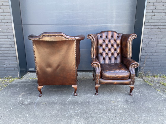 Image 1 of Twee prachtige Engelse Chesterfield oorfauteuils + voetenbank bruin leer 