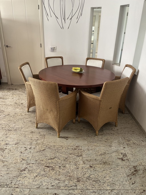 Solid cherry wood round table with beautiful matching Lloyd Loom chairs.