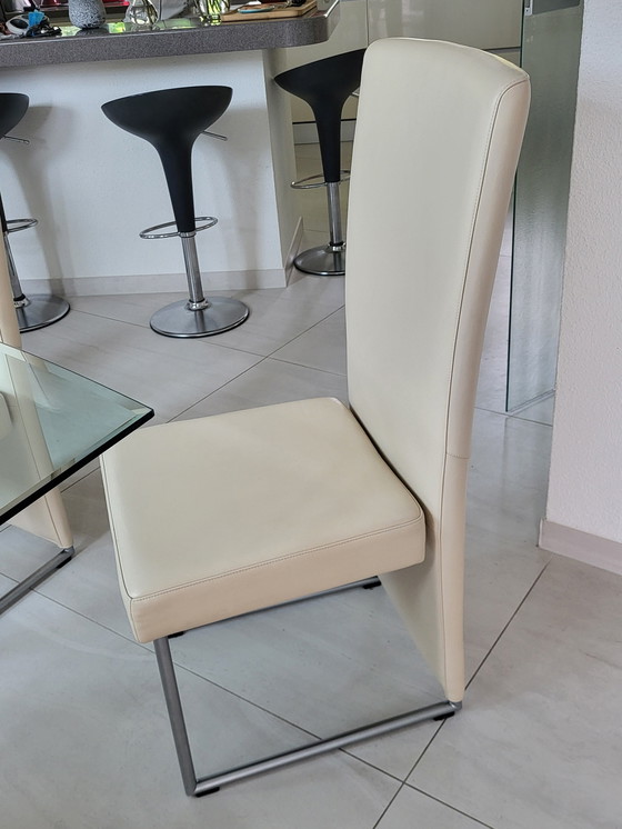 Image 1 of Table de salle à manger en verre + 6 chaises en cuir crème/blanc. Marque Rolf Benz prix 850,00€.