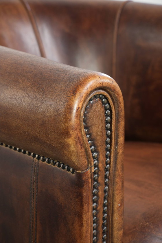 Sturdy and characterful sheepskin club armchair with a beautiful patina, finished with decorative nails. (photo 11 of 12)