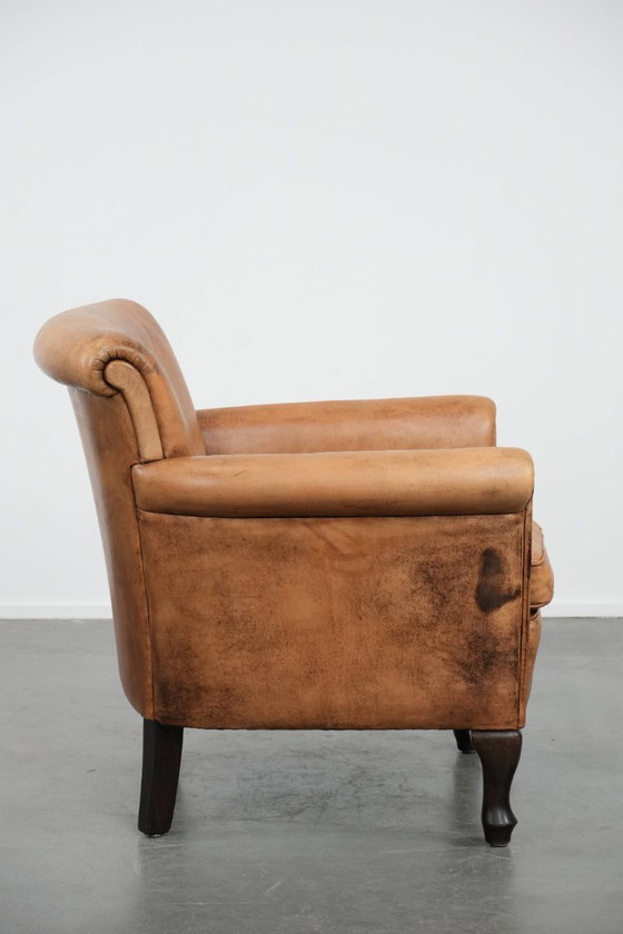 Image 1 of Fauteuil vintage discret en peau de mouton aux pieds gracieux