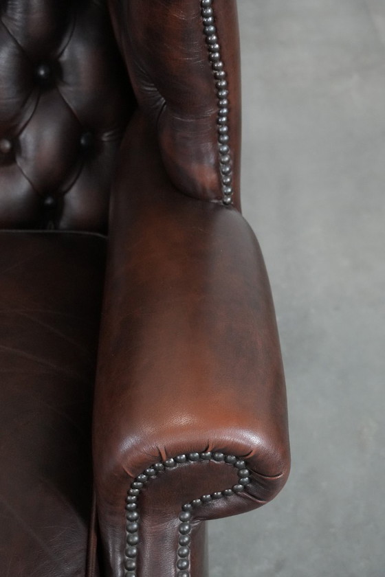 Image 1 of Tijdloze bruine rundleren chesterfield oorfauteuil in Engelse stijl
