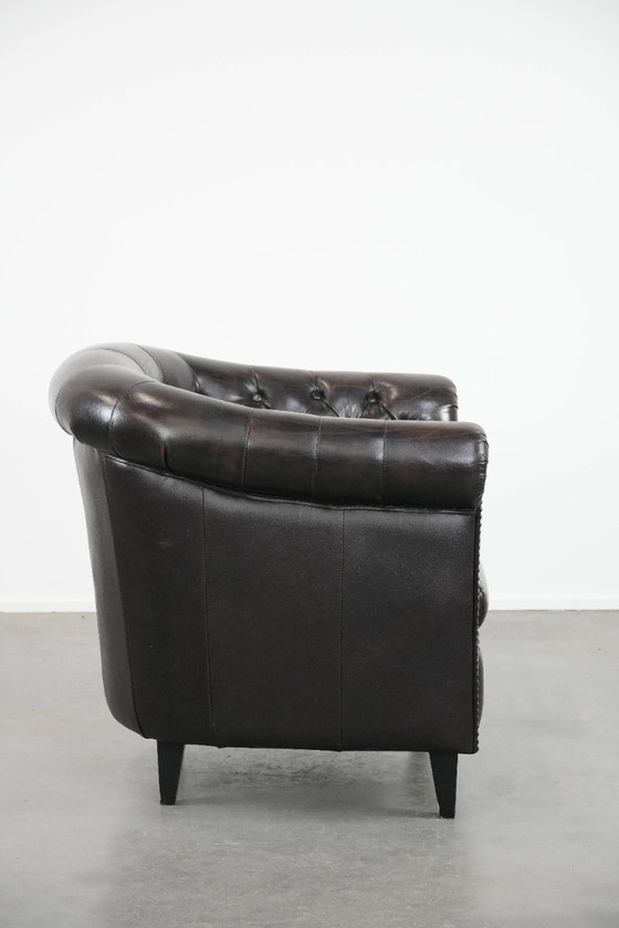 Image 1 of Donkere luxe rundleren Chesterfield clubfauteuil in Engelse stijl, afgewerkt met siernagels