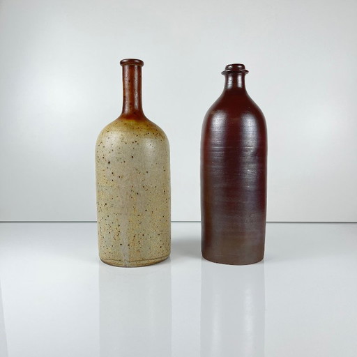 Duo of speckled stoneware and burgundy bottles
