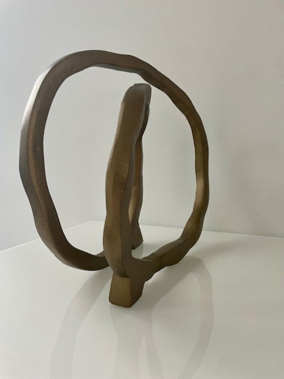 Image 1 of Escultura de diseño con forma de anillo abierto en oro mate.