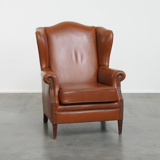 Fauteuil à oreilles en cuir de bœuf de couleur cognac de style anglais avec clous décoratifs