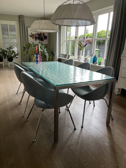 Dining table Metaform S-16. Stainless steel frame with brut glass top