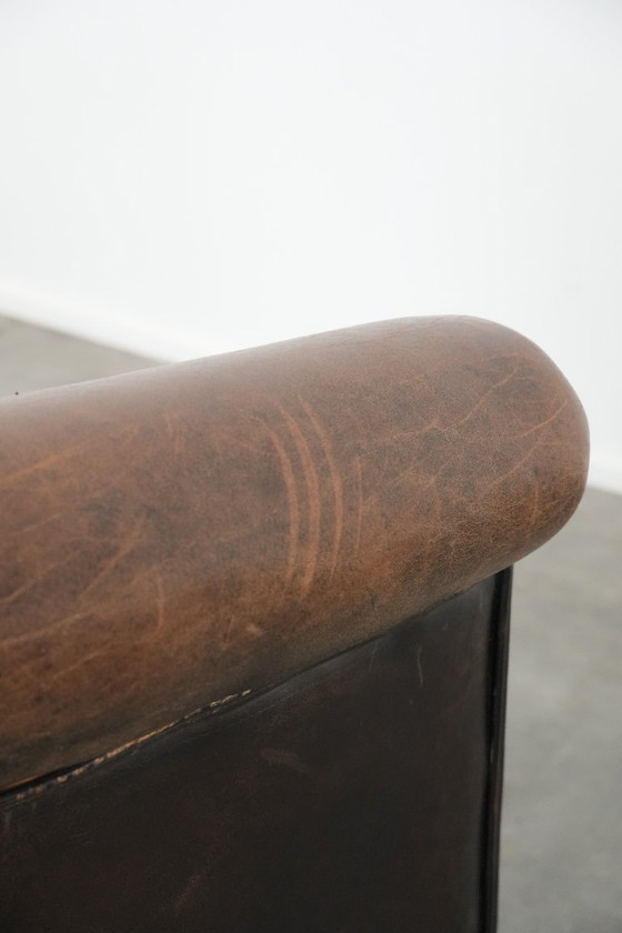 Image 1 of Karaktervolle clubfauteuil gemaakt van schapenleer met een mooi patina