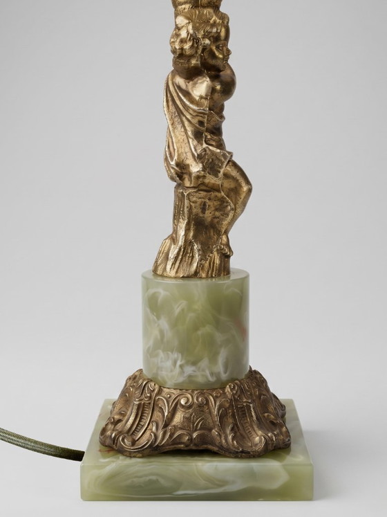 Image 1 of Lampe de table style Louis XVI au putto en métal doré et base effet onyx – 48 cm