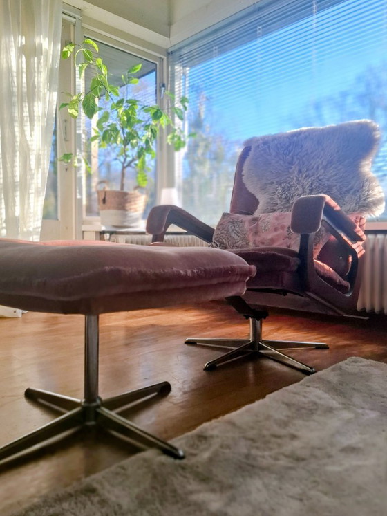 Image 1 of Sessel und Hocker im Stil der 70er Jahre in Altrosa. Beide stehen auf stabilen Metallbeinen und sind um 360° drehbar.