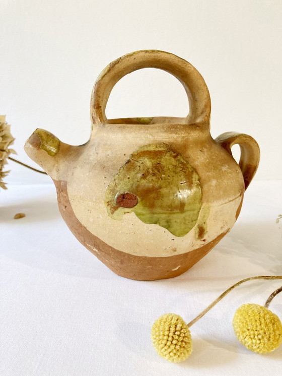 Image 1 of Klein Provençaals kannetje in de vorm van een geit, gemaakt van crèmewit en lichtgroen geglazuurd aardewerk.