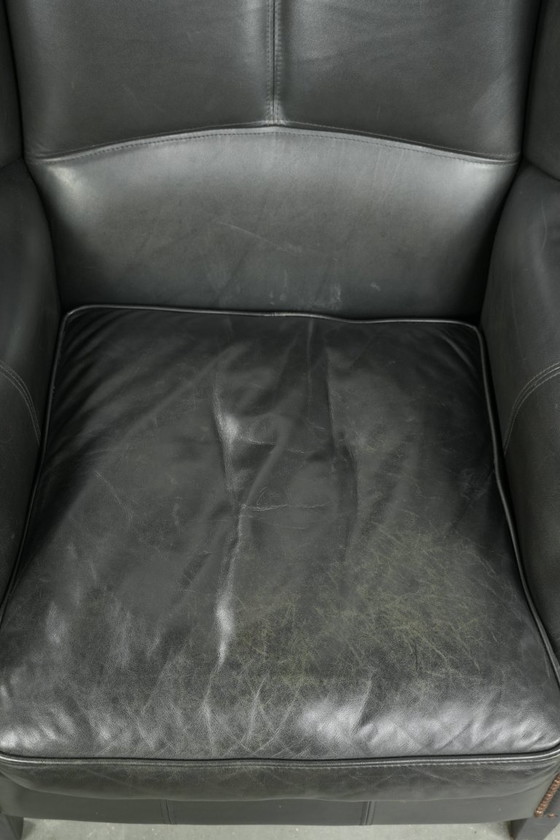 Image 1 of Zwarte rundleren oorfauteuil in een klassiek Engelse stijl
