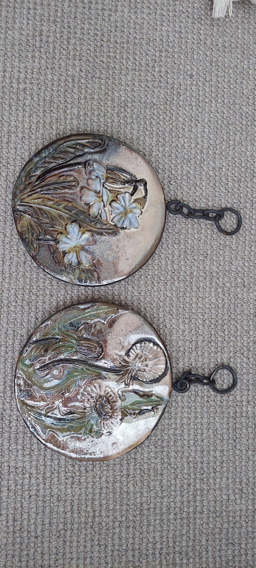 Piastrelle decorative in terracotta con motivi floreali smaltati.