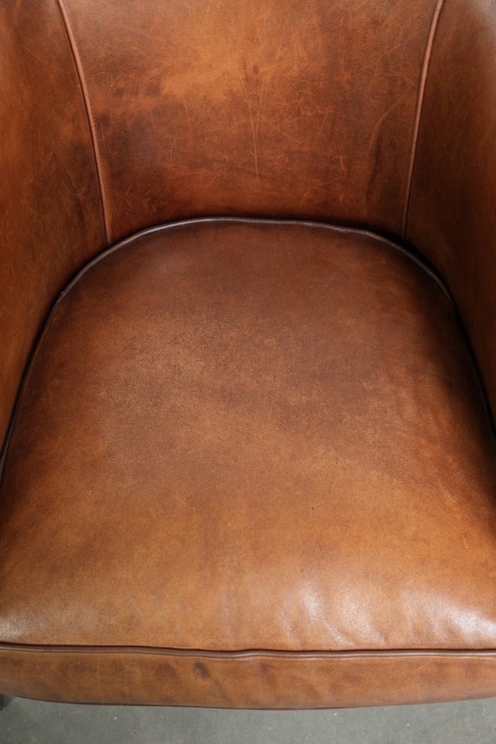 Image 1 of Poltrona club in montone color cognac caldo, rifinita con borchie decorative.