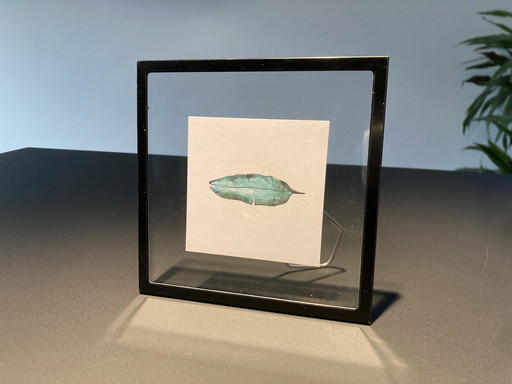 Picture frame with illustration of teal feather
