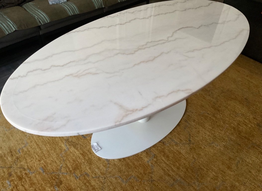 Mesa ovalada de mármol blanco.