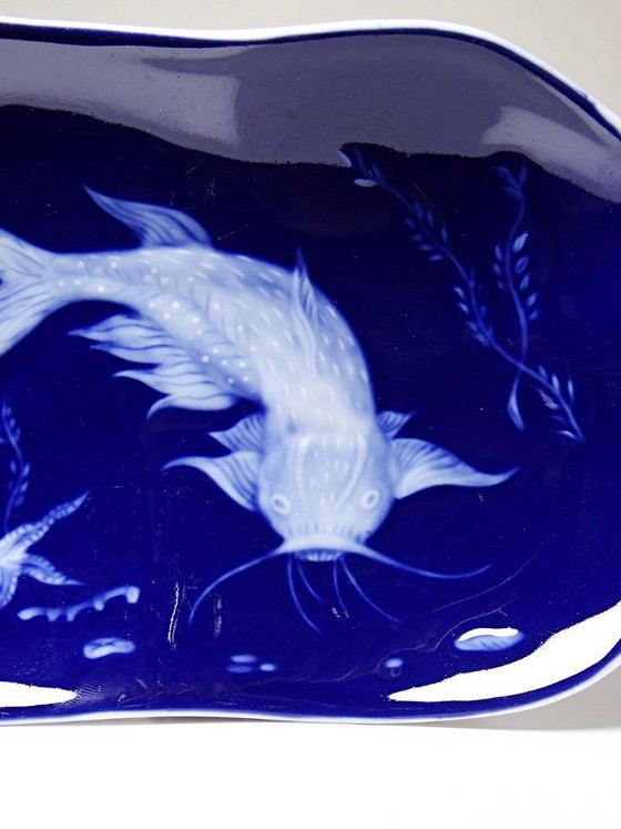 Image 1 of Plato pequeño de porcelana de Limoges con esmalte azul y decoración de peces al estilo japonés.
