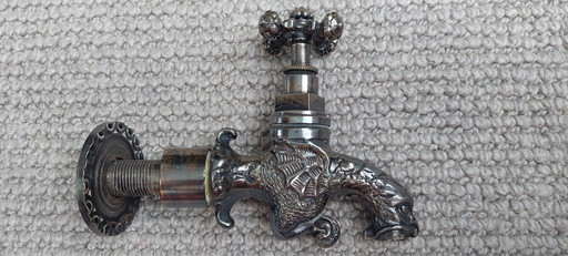 Grifo exterior antiguo con forma de dragón color plata.