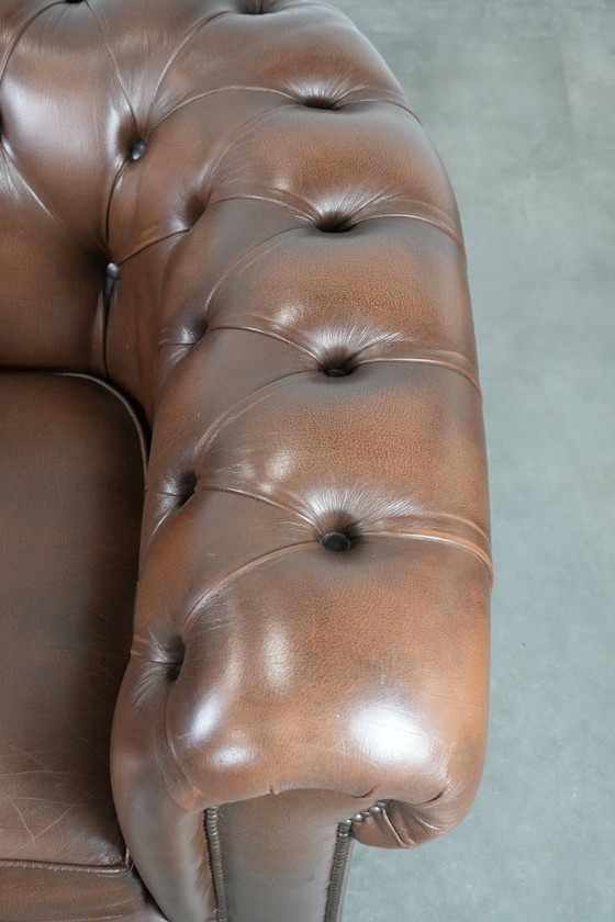 Image 1 of Impresionante sillón Chesterfield de piel de vaca marrón al estilo inglés, acabado con clavos decorativos.